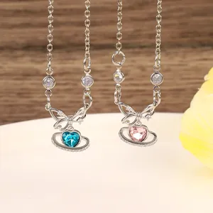 Close-up of blue and pink heart crystal pendants with bow design on silver chains
