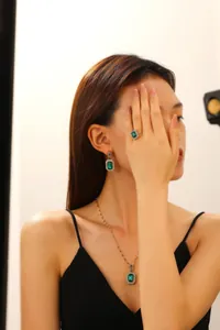 Close-up of retro emerald square gemstone jewelry set worn by a female model