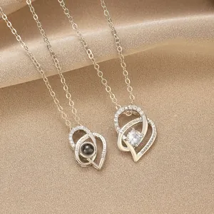 Macro detail of heart-shaped projection necklaces with crystal accents on silk fabric