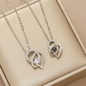 Two heart necklaces with 100 languages projection and I love you engraving in a gift box