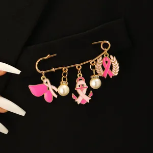Brosche mit rosa Schleifen und Perlen an goldener Sicherheitsnadel am schwarzen Blazer