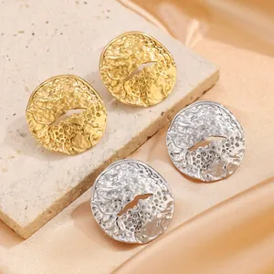 Macro detail of irregular lava texture on gold and silver stainless steel earrings