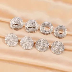 Detail view of silver irregular lava texture earrings on luxury champagne silk fabric
