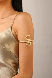 Detailed close-up of golden octopus tentacle arm cuff with circular texture on model