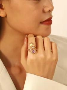 Detail van vintage zonvormige ringen met gele en paarse kralen en witte zirkonia