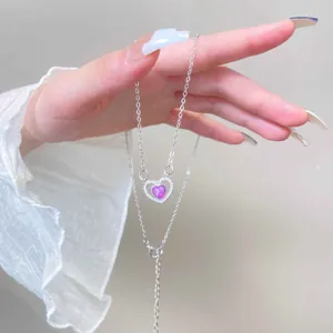 Macro-opname van een hartvormige roze stenen hanger ketting met glanzende kristallen rand
