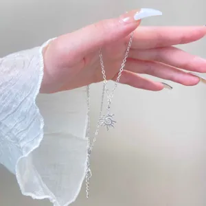 Macro-detail van een vintage zilveren zonnehanger ketting in een bohemian stijl aan de hand