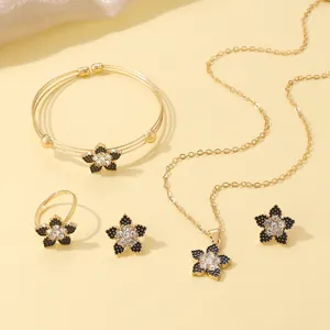 Detail showing elegant gold-plated jewelry set with black enamel petals and crystals