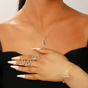 Detailed view of gold love heart jewelry set including necklace, ring and earrings