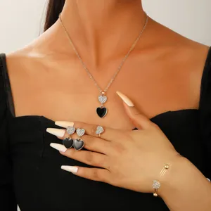 Detail view of model wearing a black heart jewelry set with necklace and earrings