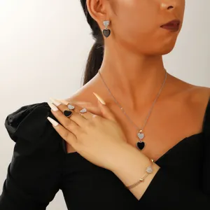 Detail of elegant black heart jewelry set on a model including necklace and earrings