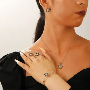 Detail of elegant gold flower jewelry set with black pavé crystals worn on model