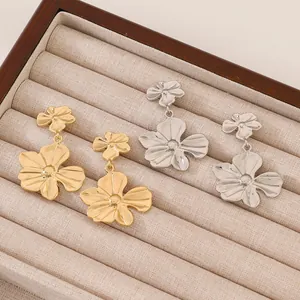 Pendientes de flores en capas con acabado dorado y plateado en bandeja de terciopelo