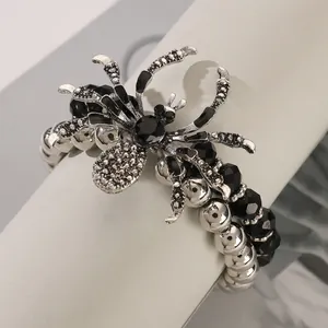 Detailed close-up of a Gothic spider pendant with black gems and silver beaded chain