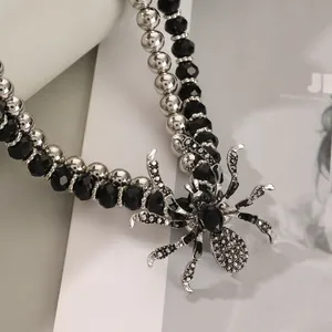 Detailed view of Gothic spider pendant with black crystals and beaded metal chain