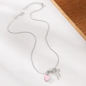 Details der silbernen Schleifen-Halskette mit rosa Herzanhänger und Sternanhänger