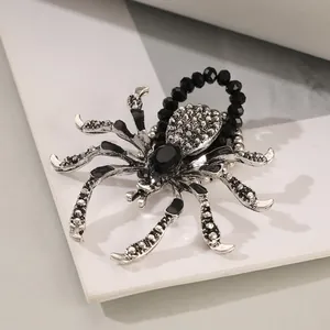 Detail of gothic spider necklace with black gemstone and rhinestone accents on silver metal