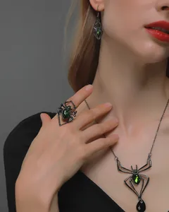 Gothic spider jewelry set close-up with black metal and green faceted gemstones