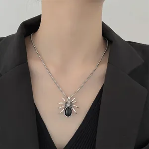 Gothic silver-tone spider pendant necklace with black gemstone worn by a model