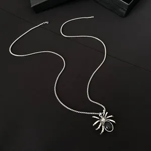 Close-up of gothic spider pendant necklace with black gemstone and silver chain