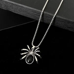 Detailed close-up of gothic spider pendant with black oval gemstone and silver chain