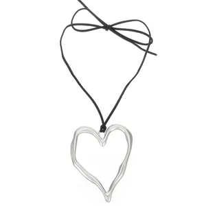 Pendentif cœur évidé en argent poli sur cordon noir avec un petit nœud élégant