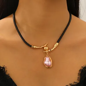 Barokke onregelmatige roze parel choker met gouden tak-textuur op een zwart koord