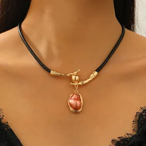 Barokke parelketting met zwart koord en gouden connector met lavatextuur op metaal