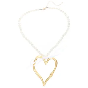 Collier en perles blanches avec grand pendentif cœur doré et nœud en ruban élégant