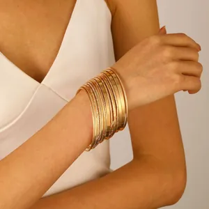 Macro shot of gold-plated bangle set featuring smooth surfaces and spiral textures