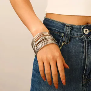 Detailed shot of silver bohemian bangle set featuring smooth, twisted, and cross-textured rings