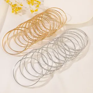 Detail of stacked gold and silver bangle set with smooth and twisted metal textures