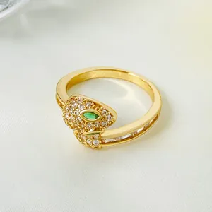 Bague serpent dorée ornée de cristaux blancs scintillants et d'yeux en gemme verte