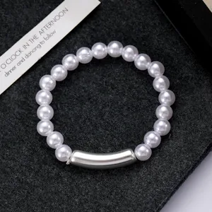 Macro detail of elegant white pearl bracelet with polished silver curved metal tube bead