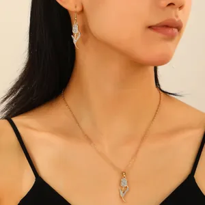 Dettaglio del set di gioielli a tulipano dorato con strass bianchi su modella