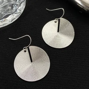 Silver disc drop earrings with concentric spiral texture and fishhook wires for women