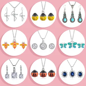 Set di gioielli minimalisti con farfalle e croci con collane e orecchini coordinati