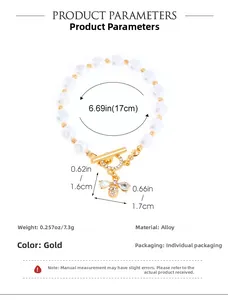 Detalle de pulsera de perlas con colgante de abeja dorada y cierre de palanca