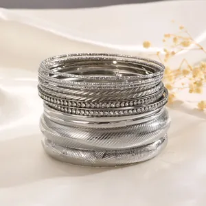 Makroaufnahme von Stapelarmbändern aus Silber mit Strasssteinen und Texturmustern