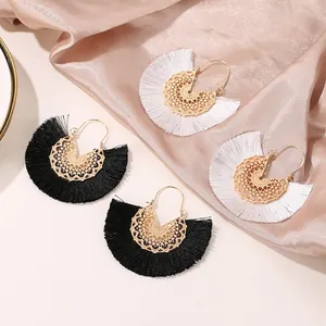 Vue détaillée des boucles d'oreilles bohèmes avec motifs en métal doré et franges
