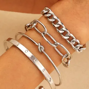 Macro detail of silver alloy bracelet set featuring engraved LOVE cuff and chain links