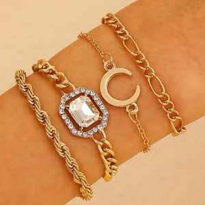 Close-up of a 4-piece gold bracelet set featuring a moon charm and a large crystal