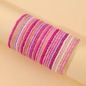 Close-up of layered elastic bead bracelets with colorful pink and purple gradient seed beads