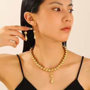 Exaggerated gold bead choker necklace with teardrop pendant and matching earrings set