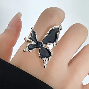 Detail of Gothic butterfly ring featuring black enamel wings and silver adjustable band