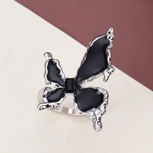 Detailed top view of gothic butterfly ring with black enamel wings and central gemstone