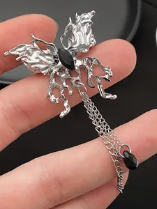 Macro detail of gothic liquid metal butterfly earring with black gem and hanging chains