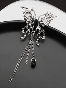 Detail of gothic black butterfly ring featuring liquid metal style and long silver chains
