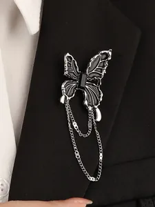 Detail of dark butterfly brooch with black enamel wings and long silver tassels on a suit jacket