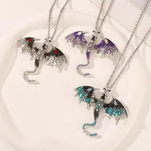 Dettaglio dei ciondoli a forma di drago smaltato con pietre preziose colorate e strass lucidi